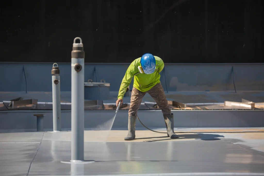 a person spray roof coating