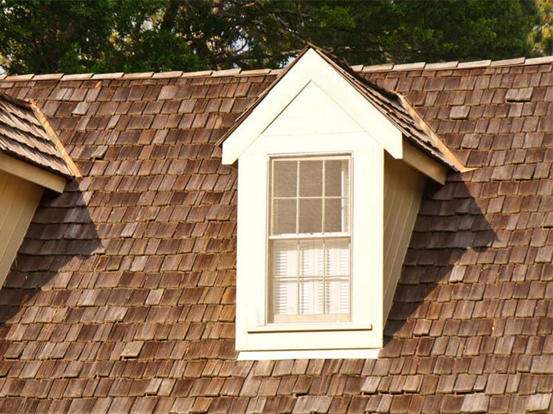 Cedar shake roof with a dormer window.