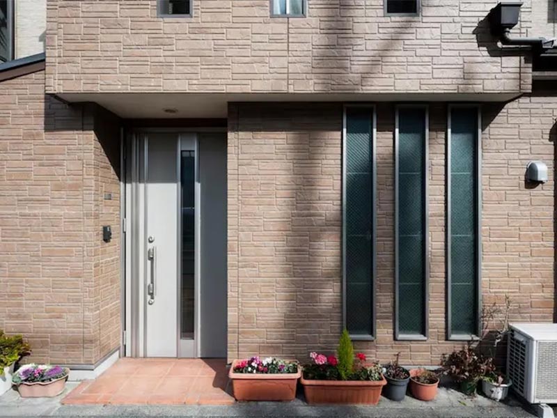 Modern house exterior with brick-style siding.