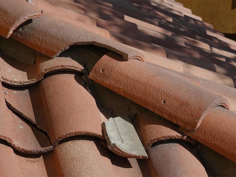 Close-up of a damaged tile roof section