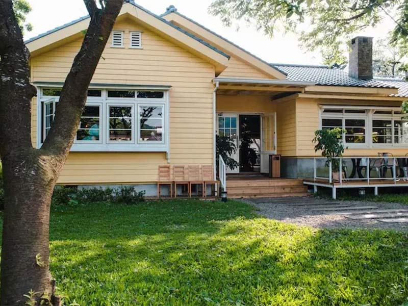 Yellow house with wood siding and front porch.