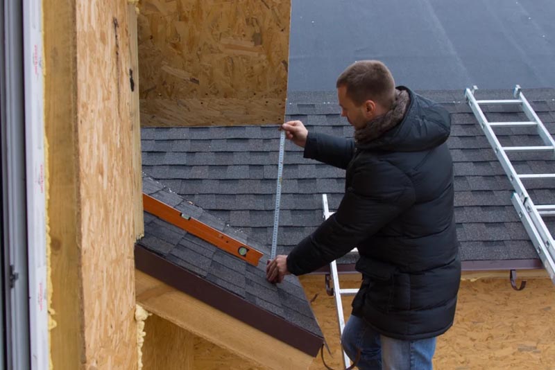 Man measuring the house roof