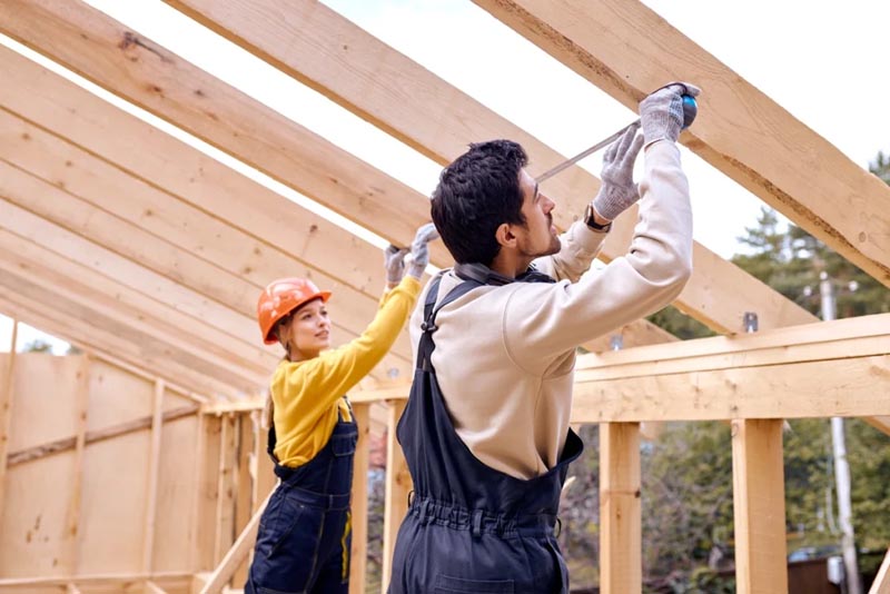 Workers measuring house roof